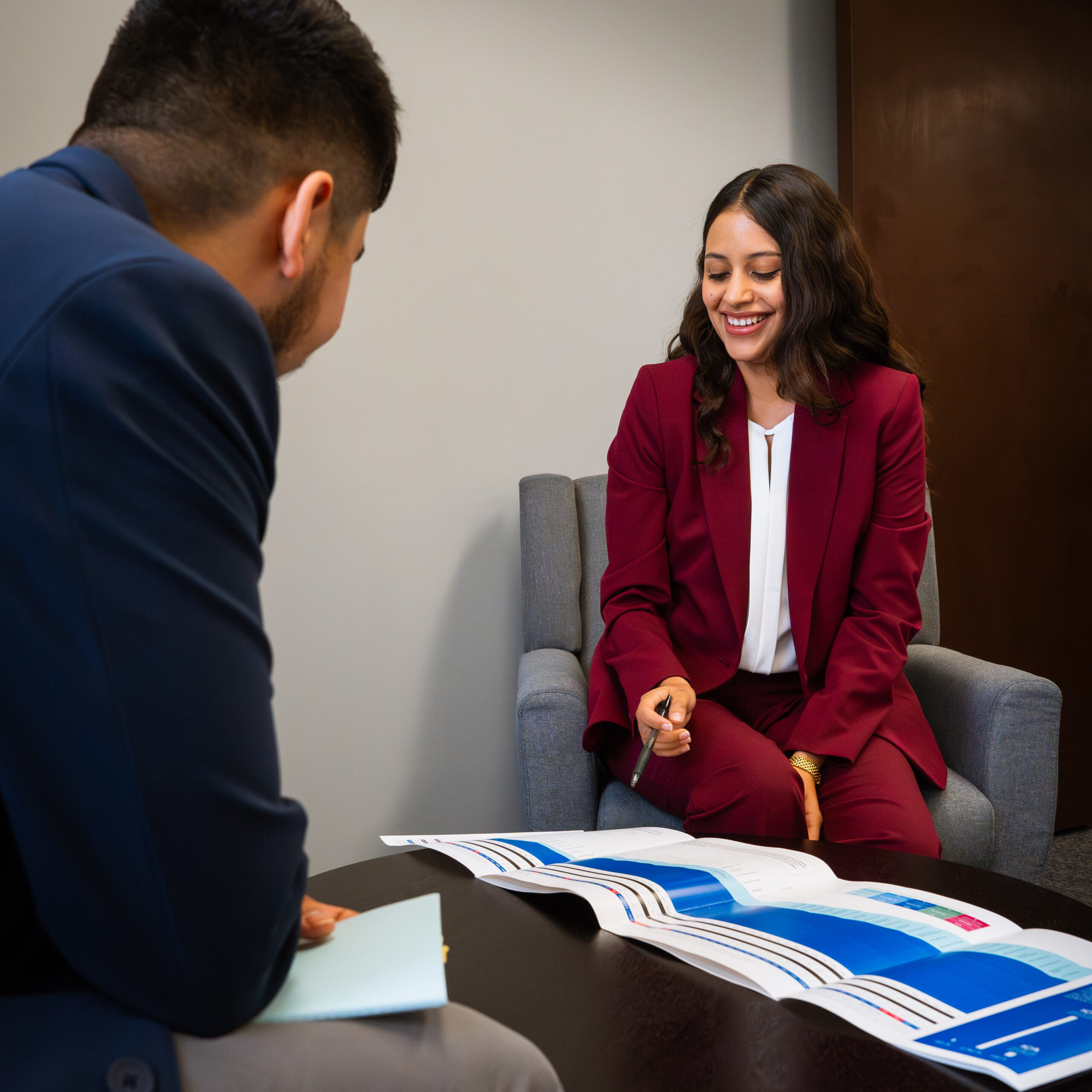 2 people looking at a paper on a desk